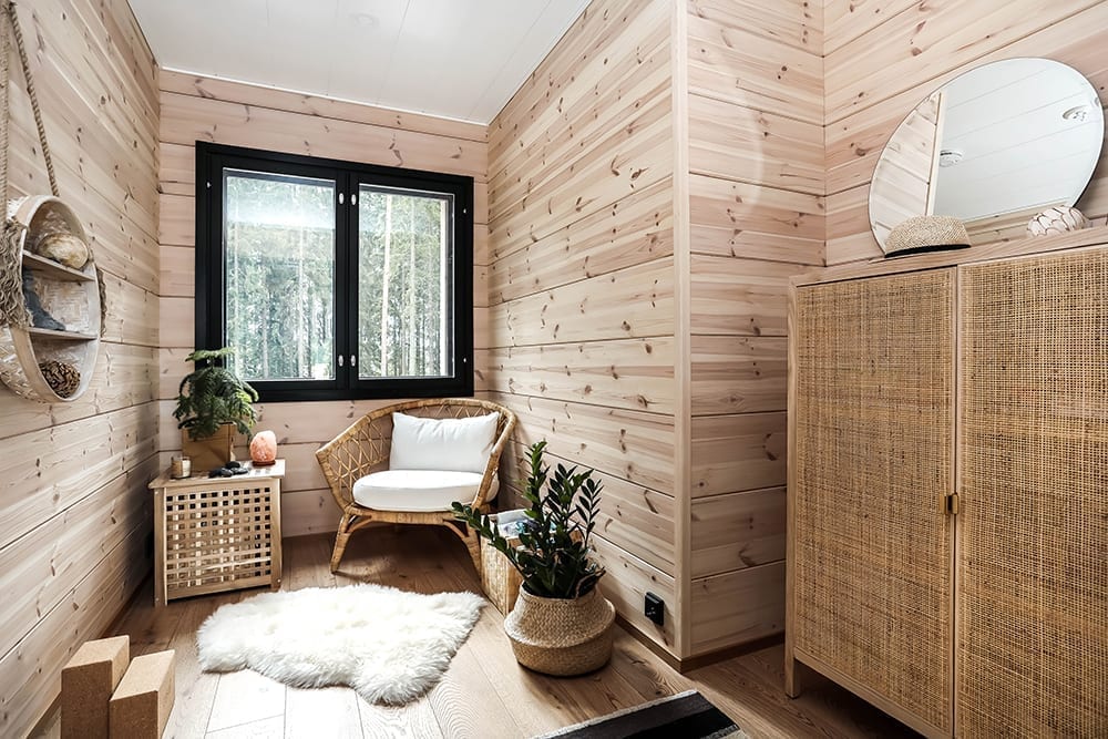 Ett svart timmerhus i lantlig miljö