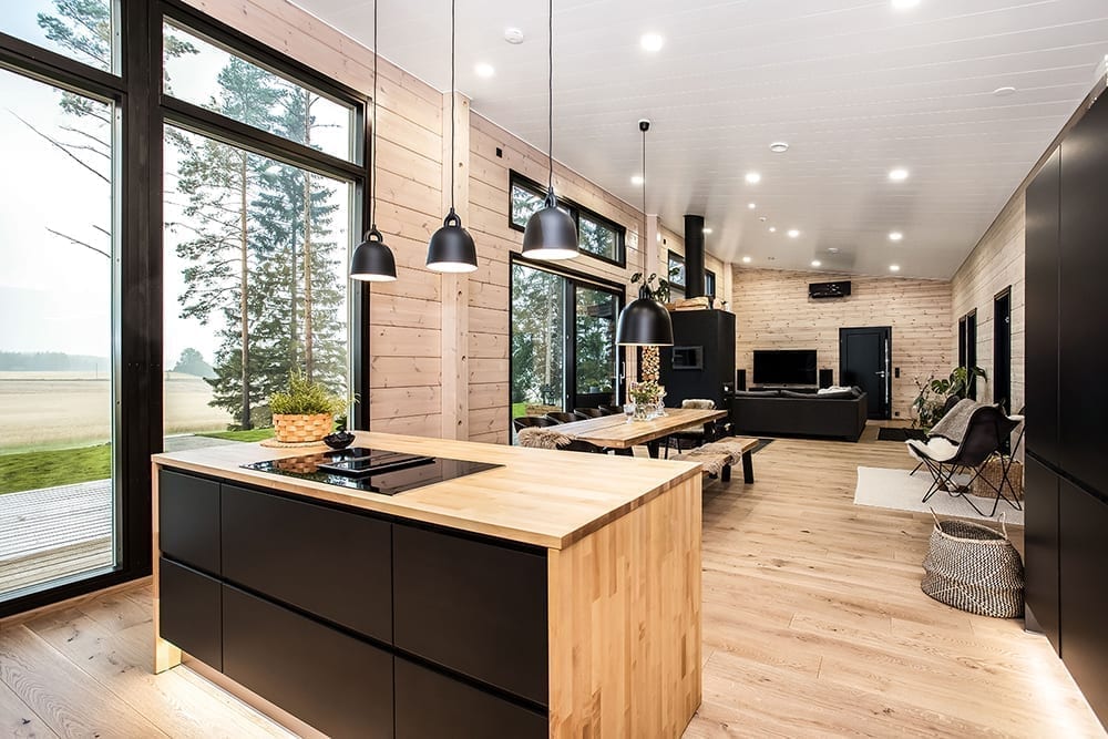 Ett svart timmerhus i lantlig miljö