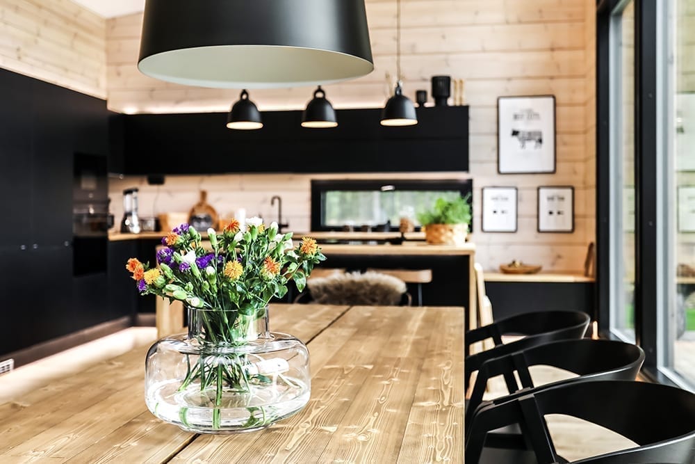 Ett svart timmerhus i lantlig miljö