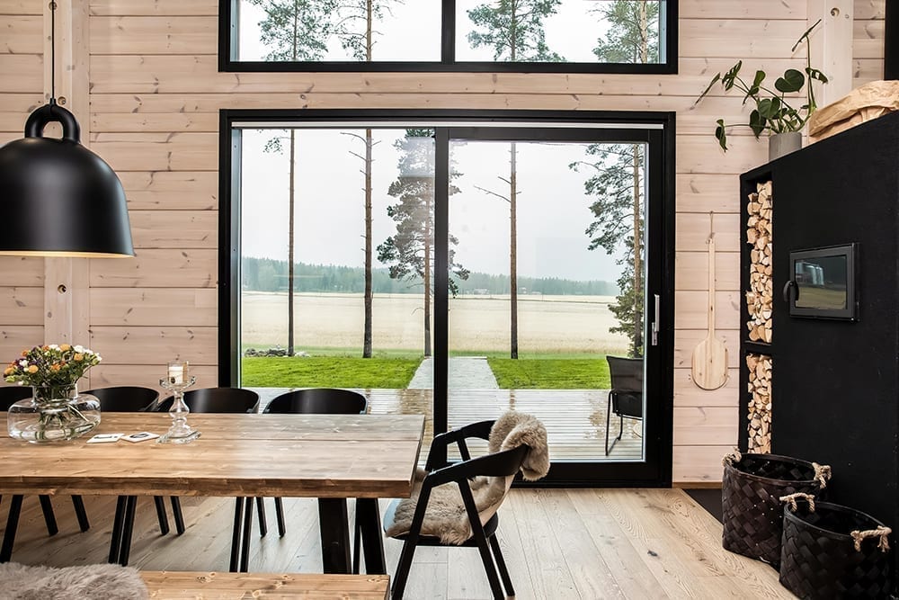 Ett svart timmerhus i lantlig miljö