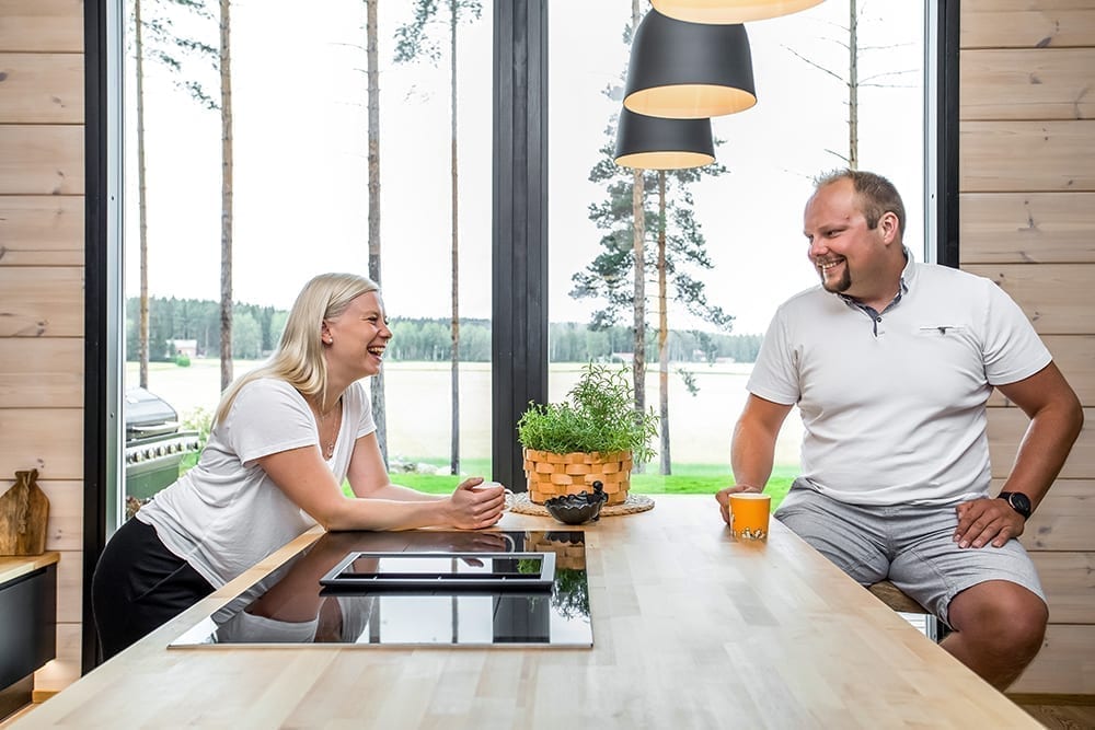 Ett svart timmerhus i lantlig miljö