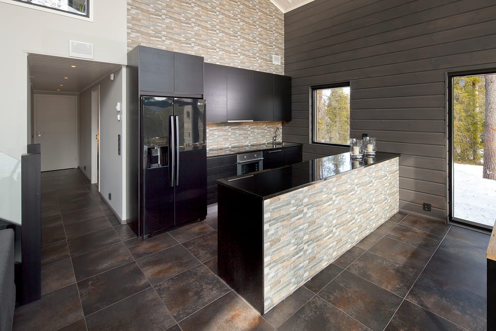 En design från Honkas portfölj anpassades till familjens krav. Eftersom marken för projektet redan säkrats kunde teamet sätta igång och fokusera på designen. Föräldrarna ville ägna sin fritid åt sina barn och låta proffsen sköta byggprocessen. För Jonna och Ilkka var det viktigt att huset skulle smälta in väl i omgivningen. För detta ändamål valde de gråa ytterväggar och svarta fönsterkarmar. Köket och vardagsrummet är i ett och samma utrymme med högt i tak och ett nio meter brett och sex meter högt glasfönster. Detta gör att de kan njuta fullt ut av utsikten.